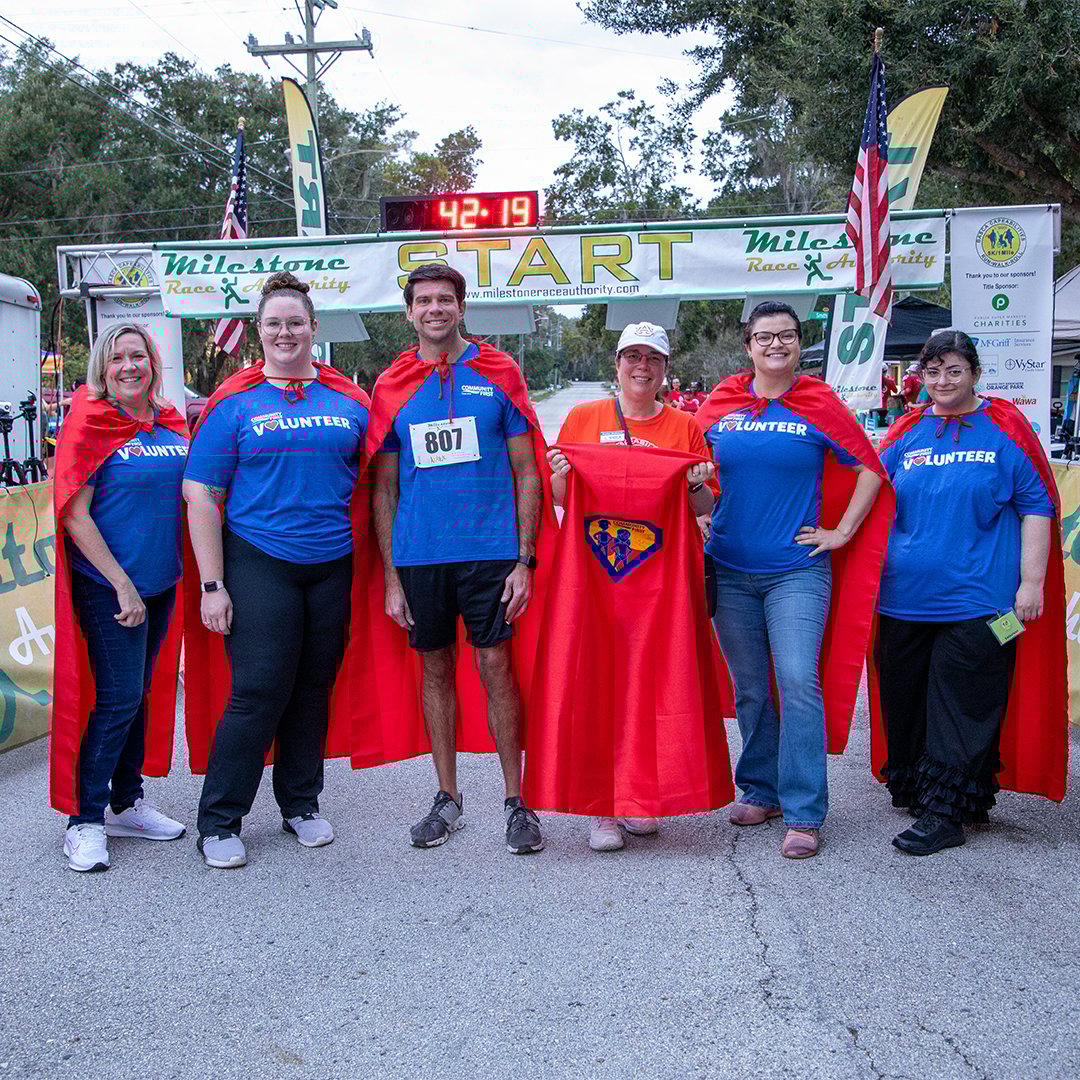 Volunteers at BASCA race wearing capes.