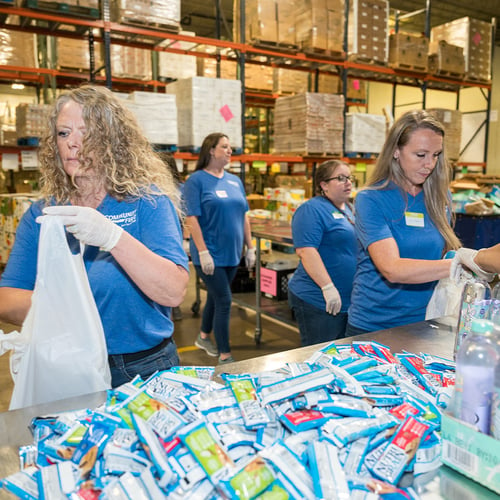 Volunteers bagging food.