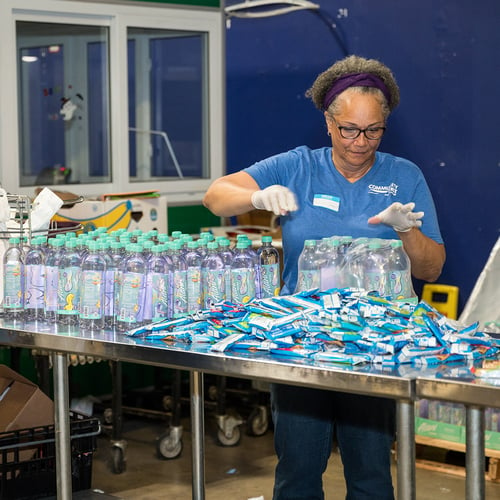Volunteer sorting water.