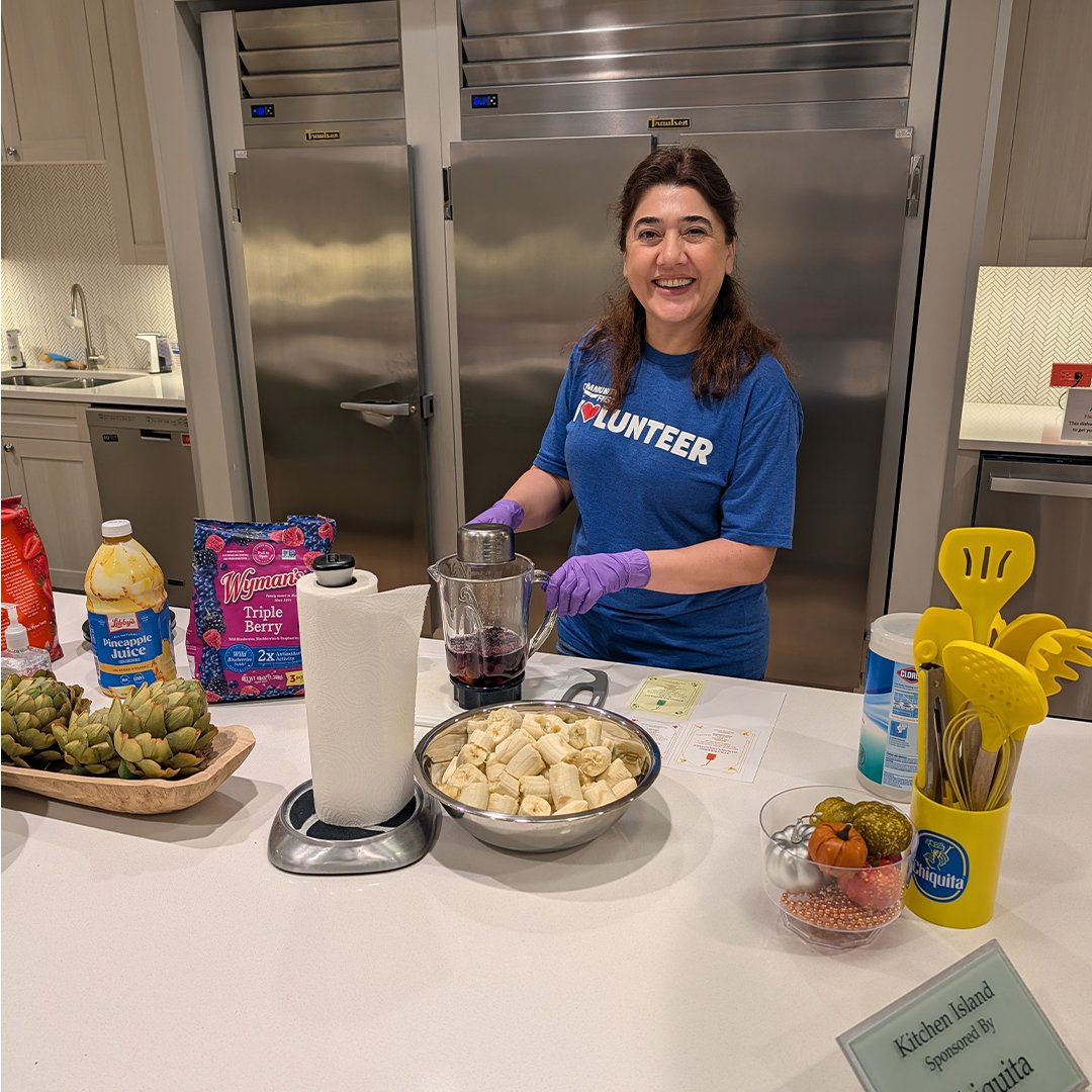Volunteer smiling while prepping smoothie.