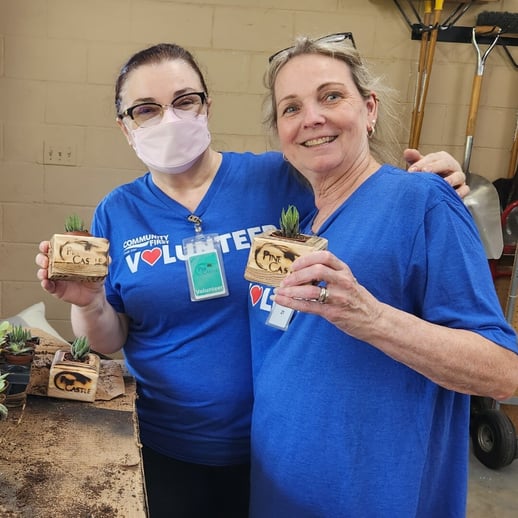 Volunteers holding handmade cactus pots.