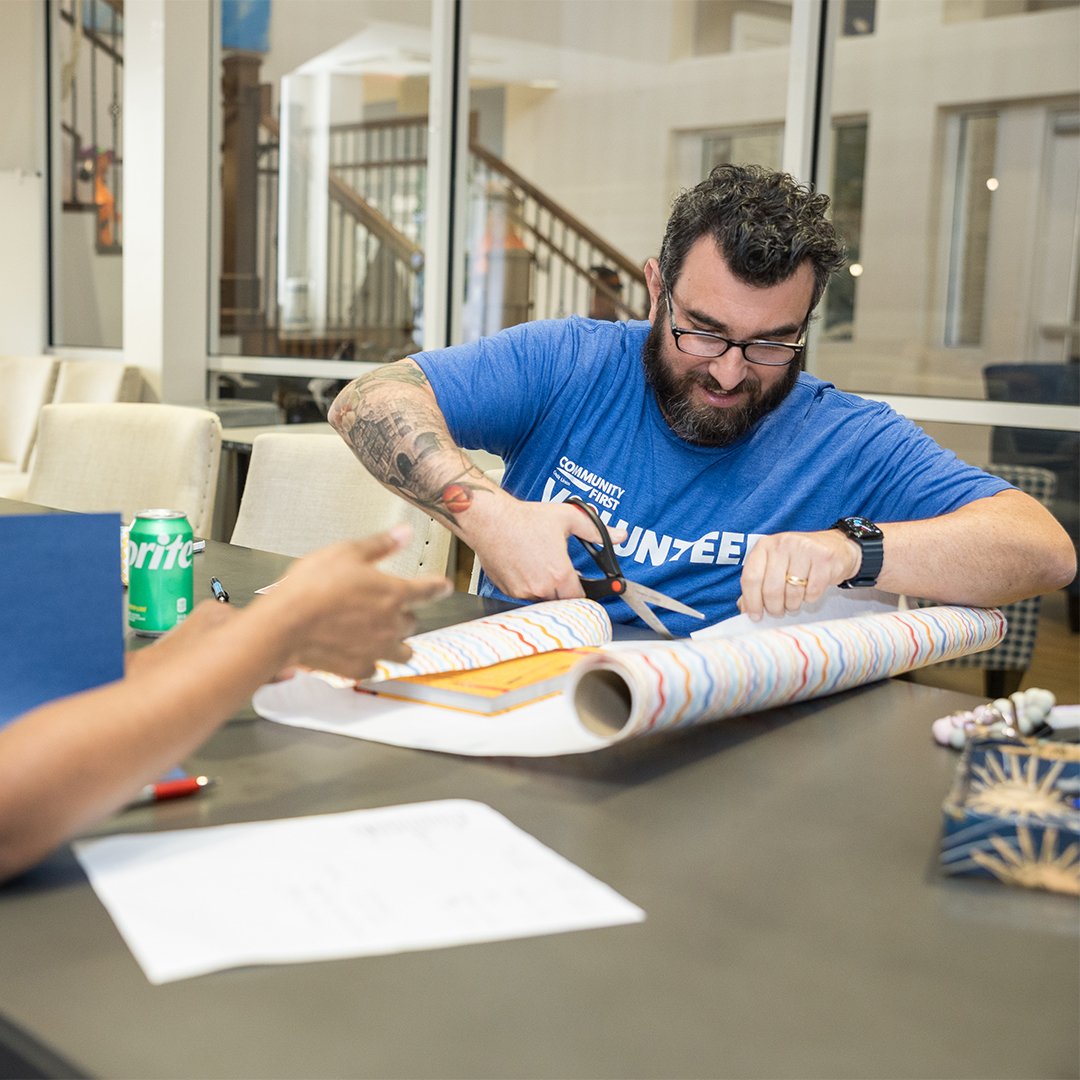 Volunteer cutting wrapping paper.