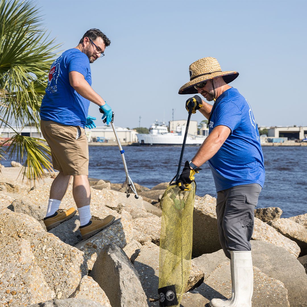 Two volunteers picking up trash.