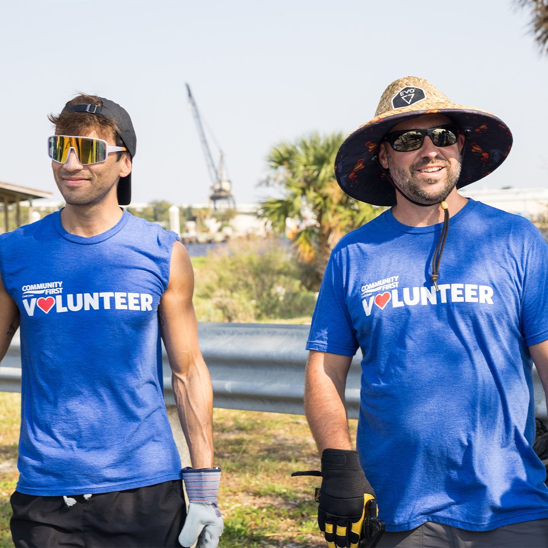 Two volunteers smiling.