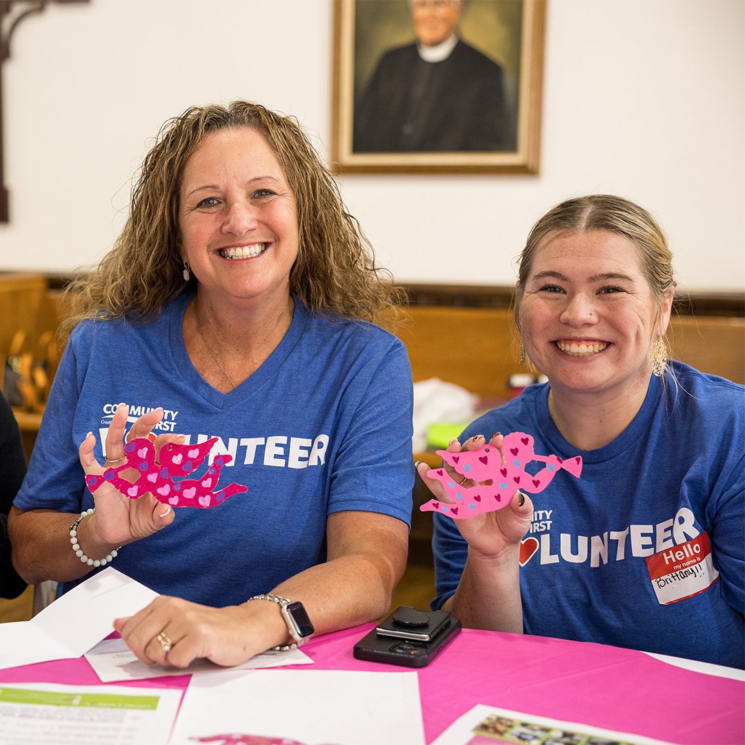 Volunteers smiling with crafts.