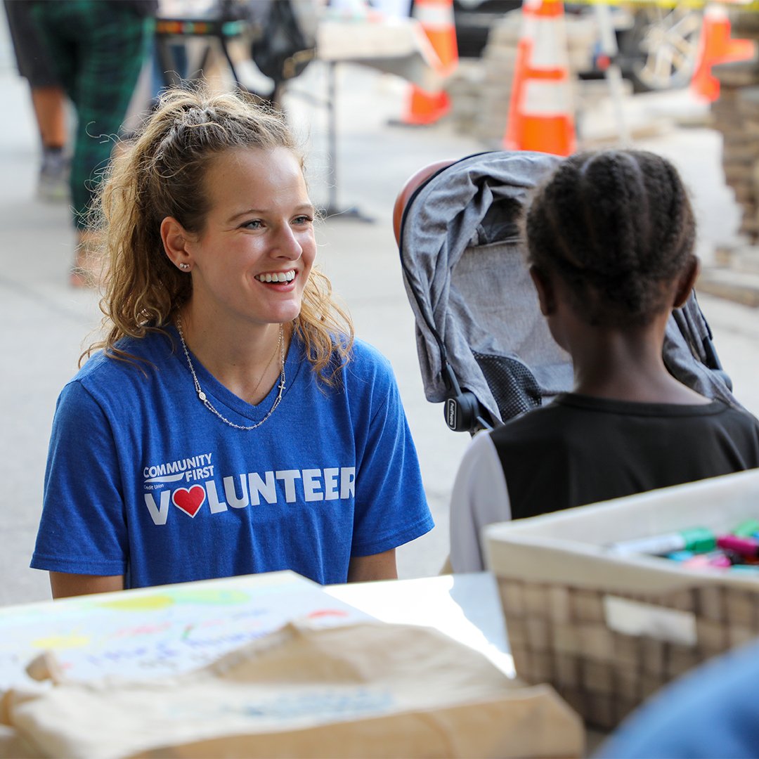Volunteer smiling at child.