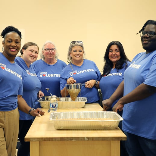 Volunteers smiling while making apple butter.