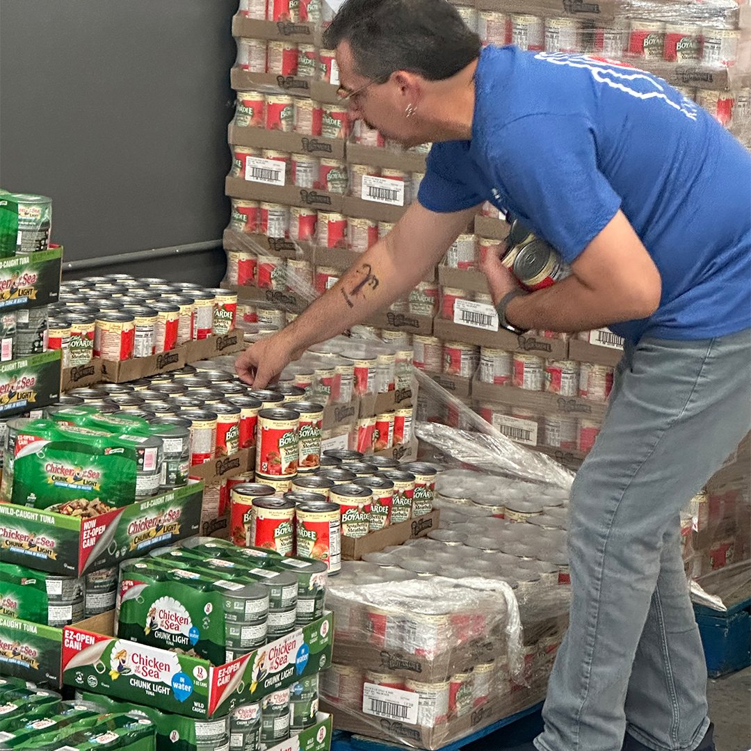 Volunteer sorting canned goods.