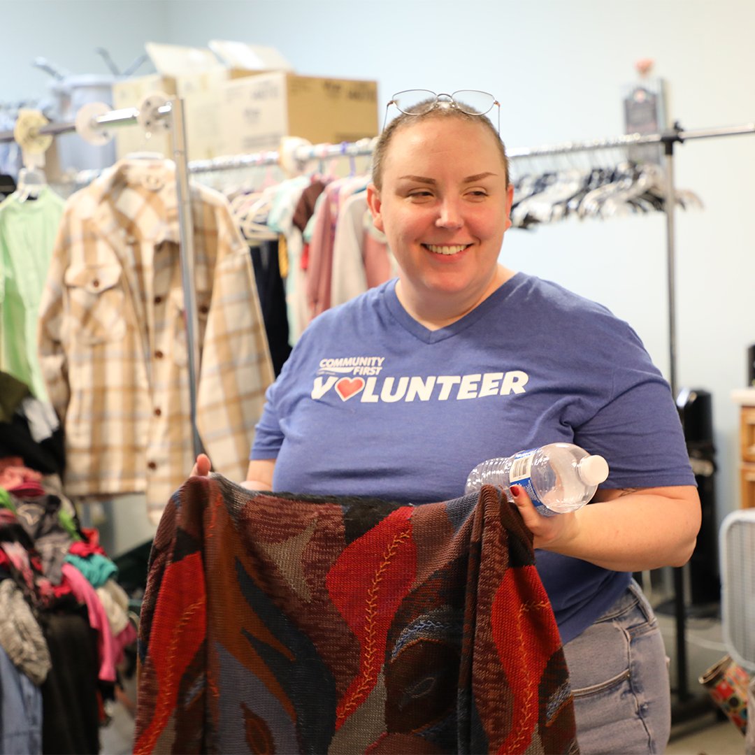 Volunteer folding clothing. Volunteer folding clothing.