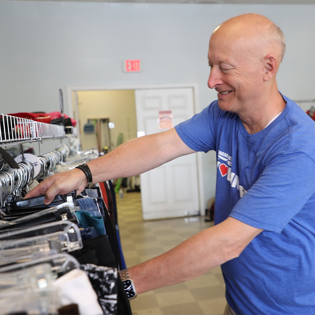 Volunteer sorting clothing on rack Volunteer sorting clothing on rack